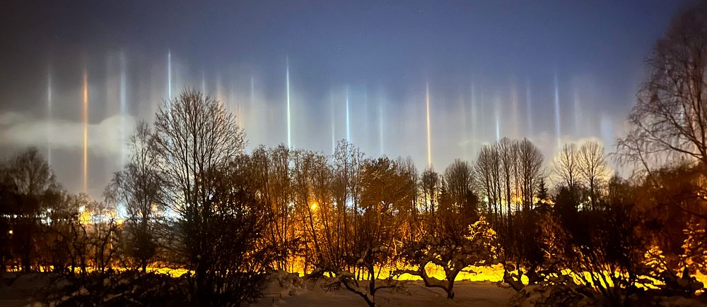 Ljuspelare på himlen. Där gatulysens ljus reflekteras upp i himlen. Ser nästan ut som norrsken.