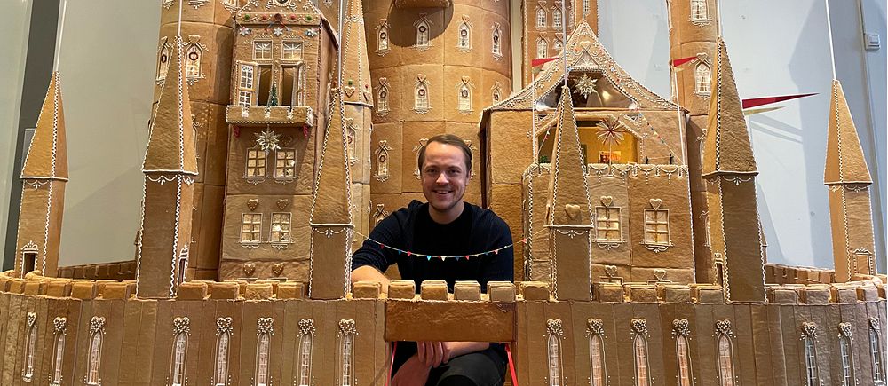 En ung man sitter i sitt gigantiska pepparkaksslott.