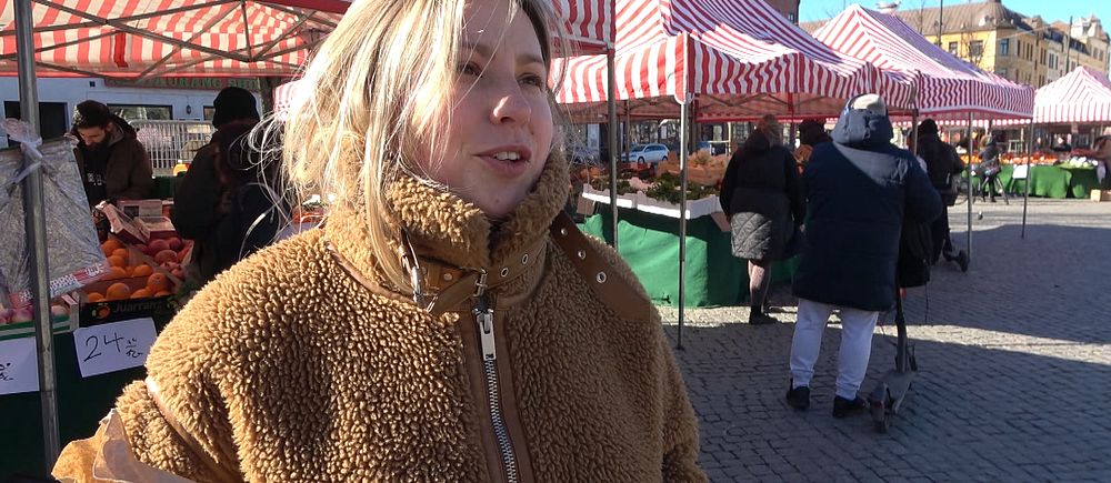 Person i brun jacka på matmarknaden på Möllevångstorget.