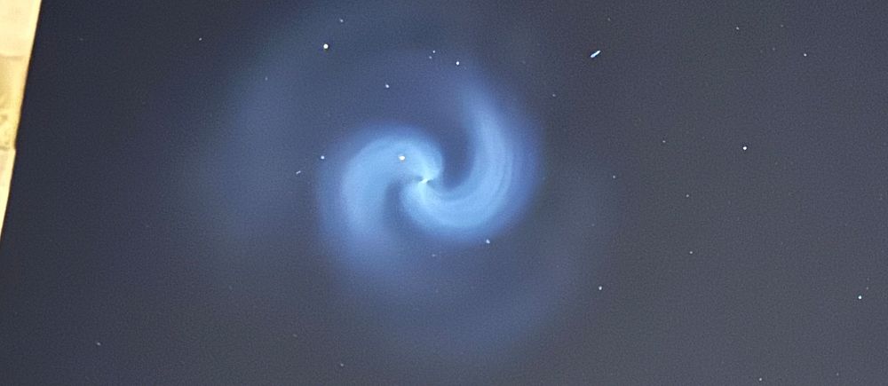 Stjärnhimmel med blå spiralformad ljusformation i centrum.