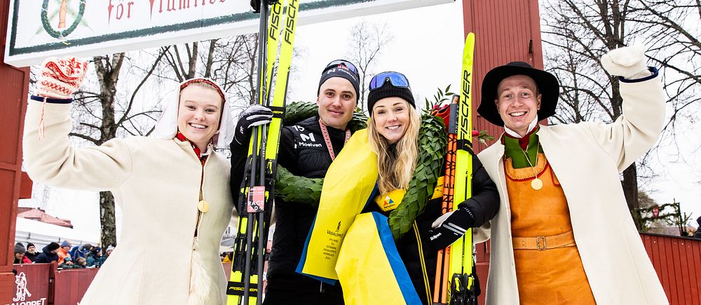 Segrarna i Vasaloppet 2024, Torleif Syrstad och Emilie Fleten, tillsammans med  kranskullan Elsa Hermansson och kransmasen Gustav Johnsson poserar vid målgången i Mora.