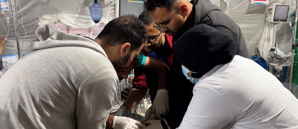 Flera personer hjälps åt att behandla patient på sjukhus i Gaza