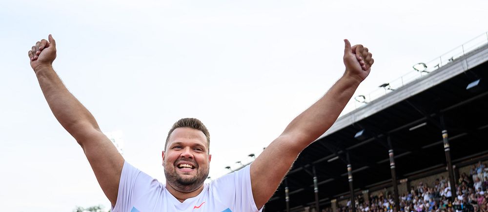 Daniel Ståhl firar med armarna i luften inför publik under Diamond League-tävling.