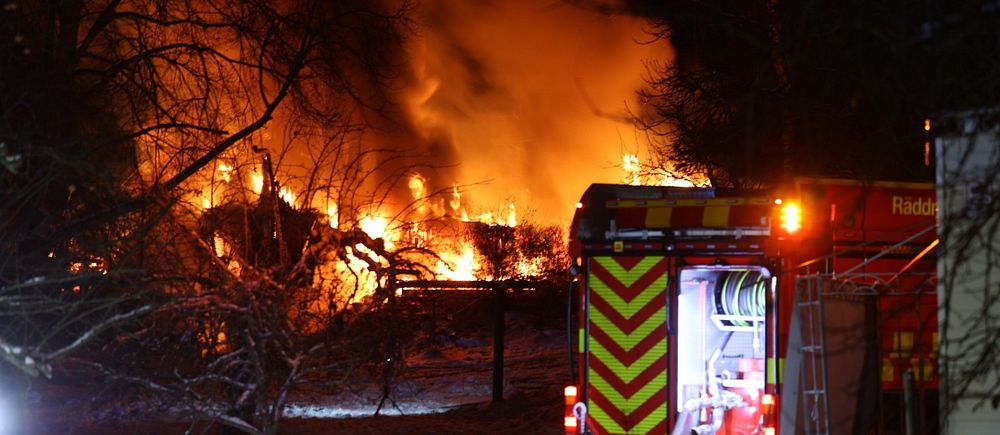 Villa i lågor. Brandbil står bredvid