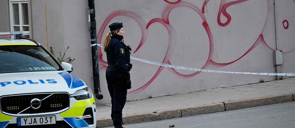 En polis står vid avspärrningarna efter skjutningen på Allhelgonagatan på Södermalm.