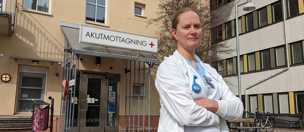 Johanna Sundesten i vita vårdkläder framför akutmottagningens ingång i Umeå.
