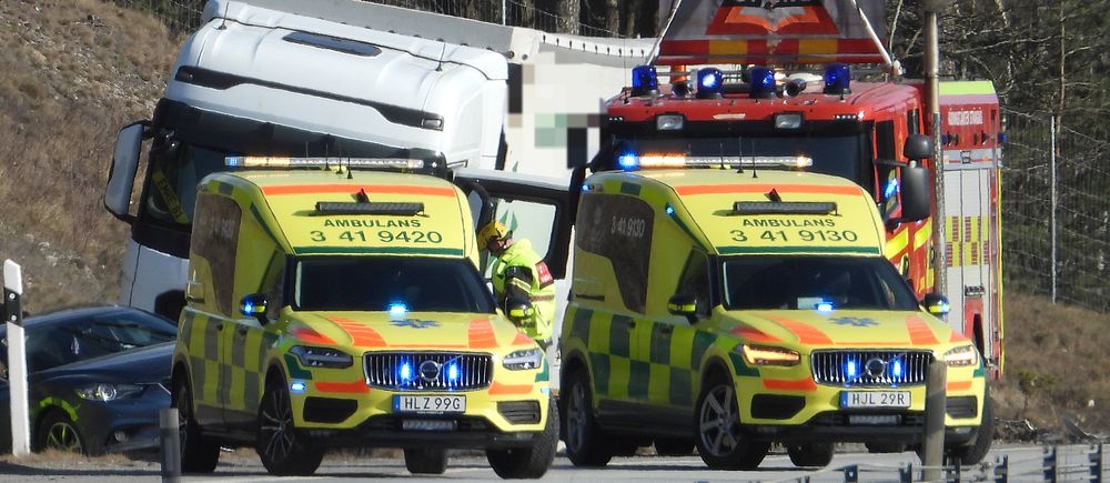 Ambulanser och brandbil vid en lastbil på motorväg.