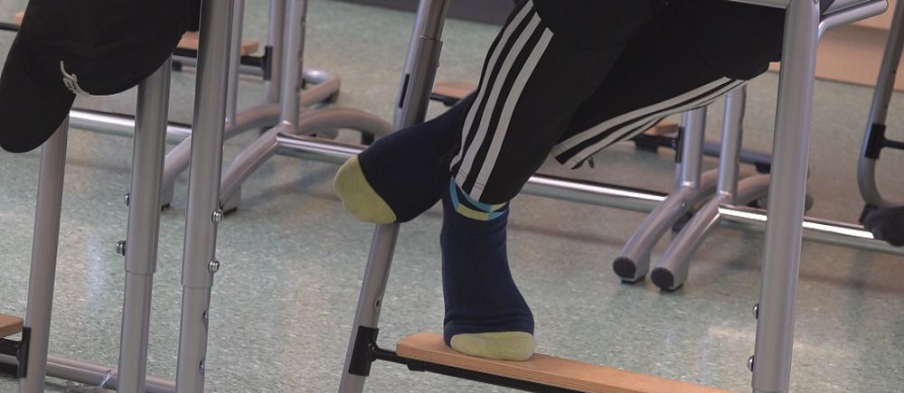En bild på ben under en skolbänk.