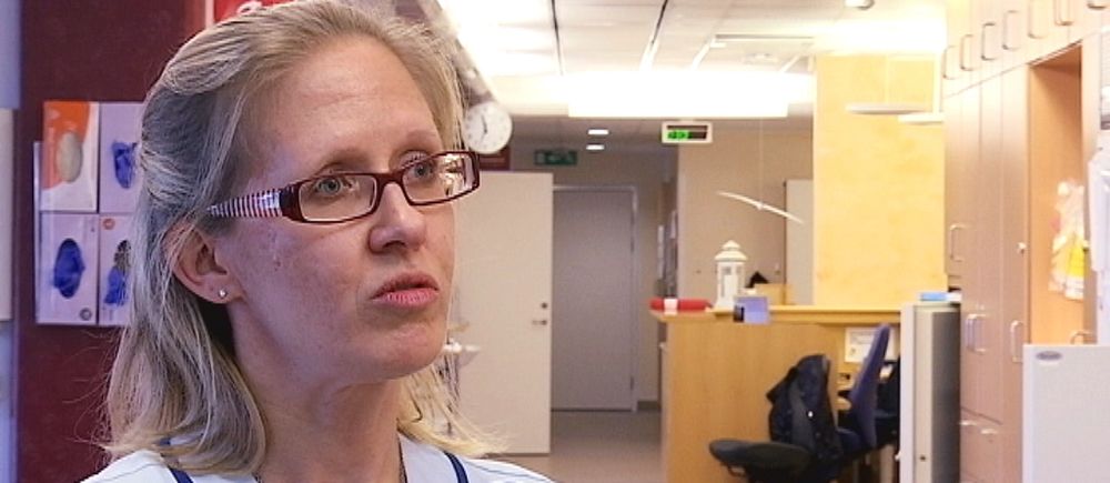 Porträttbild på sjuksköterskan Annki Svedberg som står i en sjukhuskorridor.