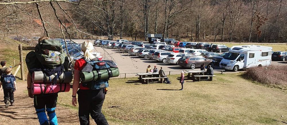 Vandrare framför parkeringsplats