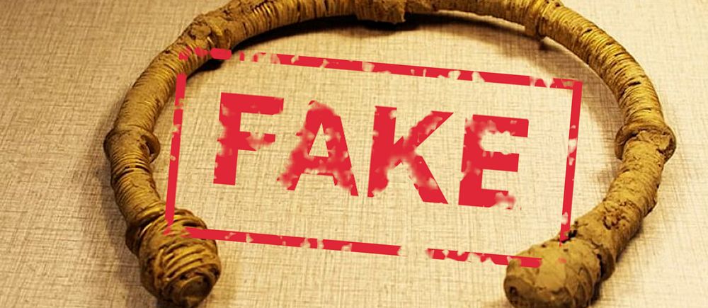 Antik ring med ordet ”FAKE” tryckt i rött över.