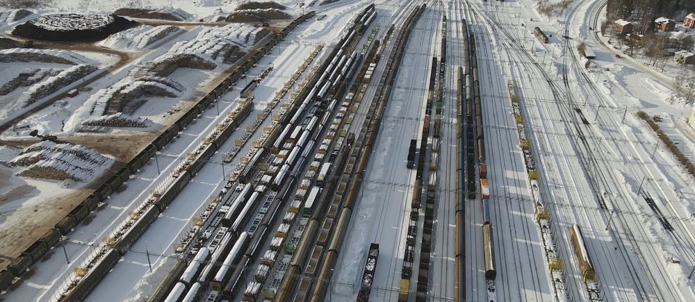 På bilden syns Ånge bangård filmas med drönare ovanifrån med järnvägsspår, tågvagnar och snö på marken.
