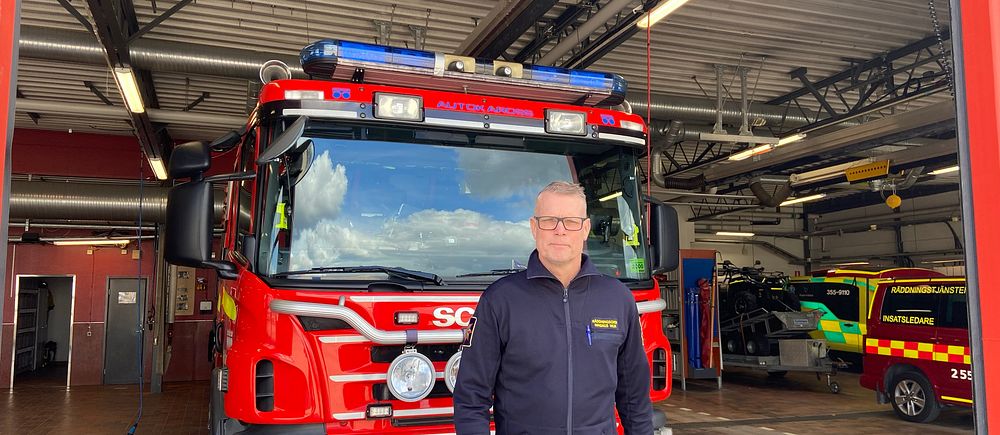 Räddningschef Magnus Wijk framför en brandbil på brandstationen i Halmstad.