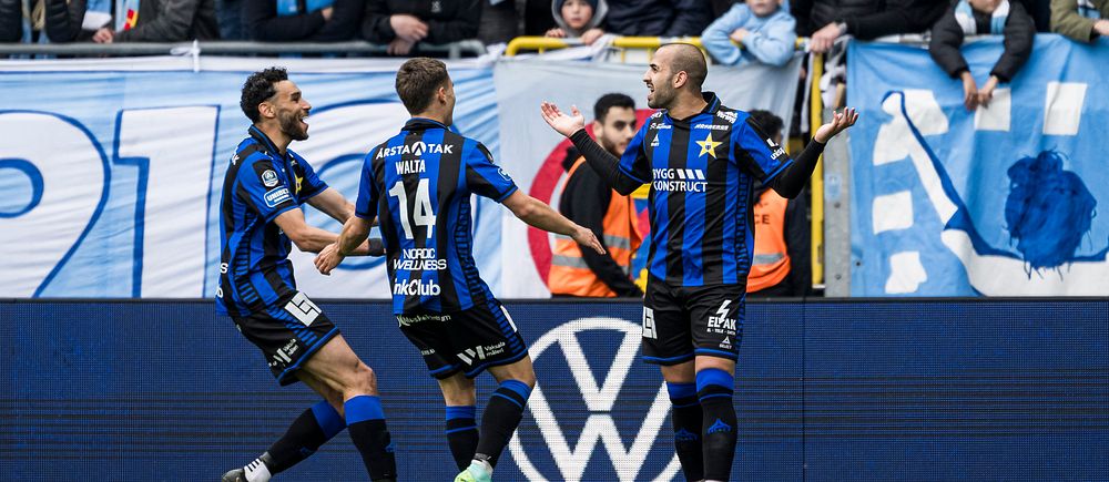 Fotbollsspelare firar mål framför jublande publik på läktaren.