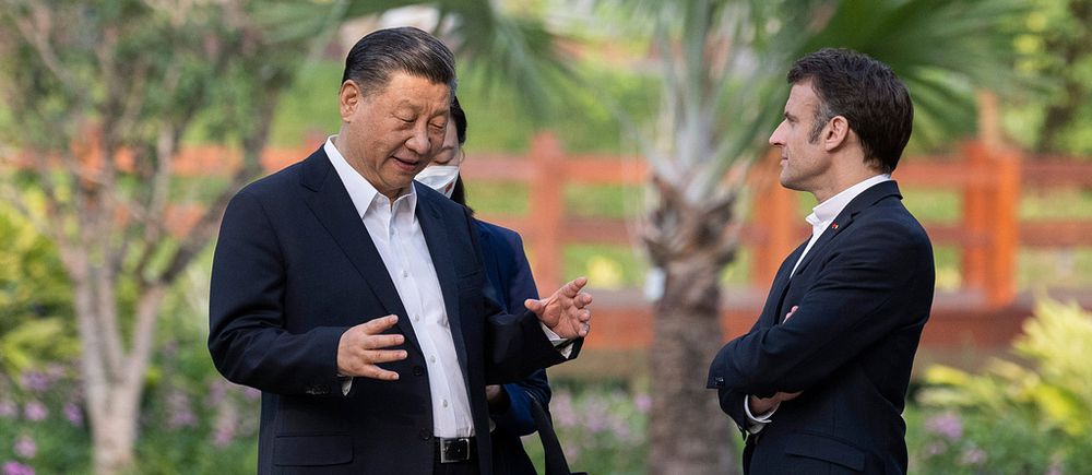 Xi Jinping med Emmanuel Macron. Två män pratar utomhus.
