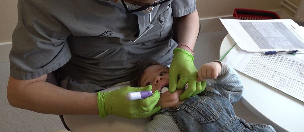 Tandsköterska undersöker en bebis tänder