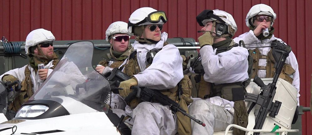Fem militärer sitter på en en snöskoter i Kiruna.