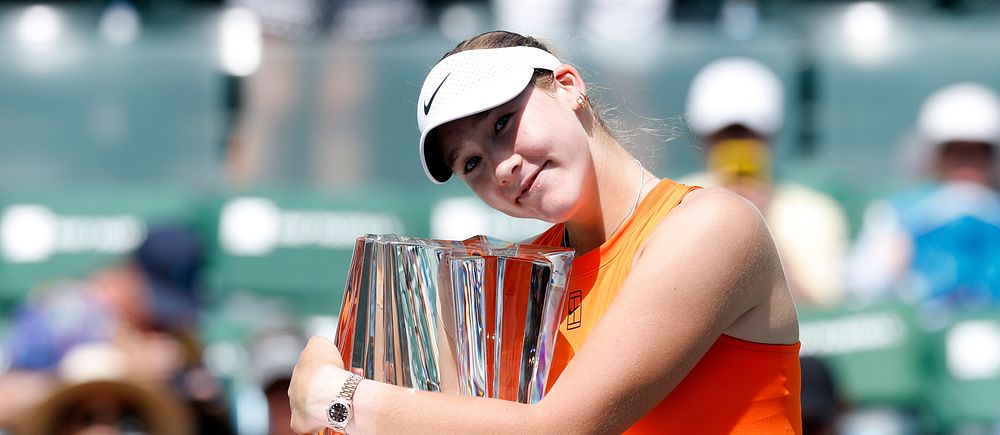 Tennisspelare jublar och kramar om pokalen