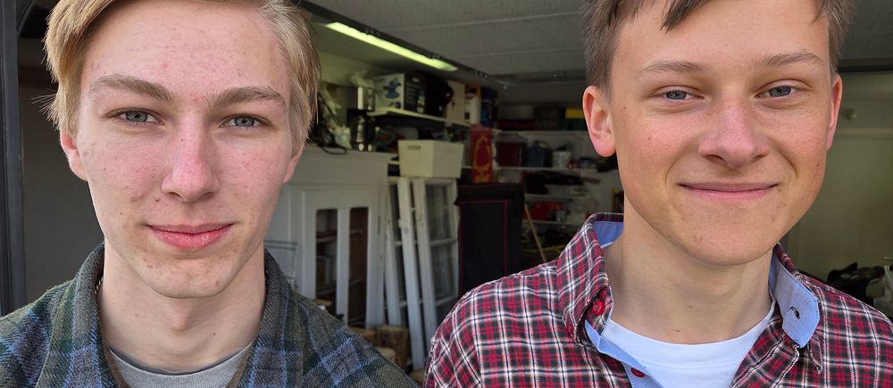 Två personer i rutiga skjortor står framför en garagelokal med verktyg och föremål.