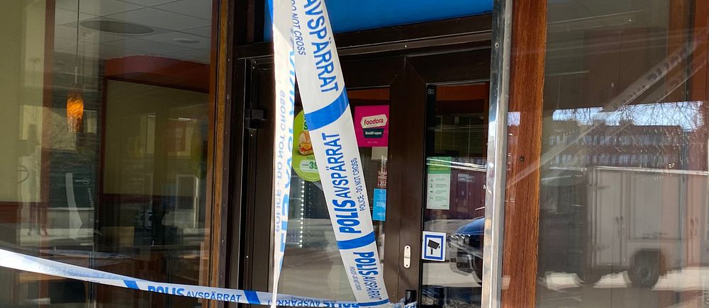 Polisens avspärrningsband hänger framför restaurangdörr