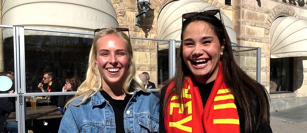Två personer intervjuas utomhus, en bär supporterhalsduk och den andra håller SVT-mikrofon.
