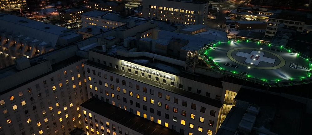 En drönarbild över Norrlands universitetssjukhus och helikopterplattan på kvällen.