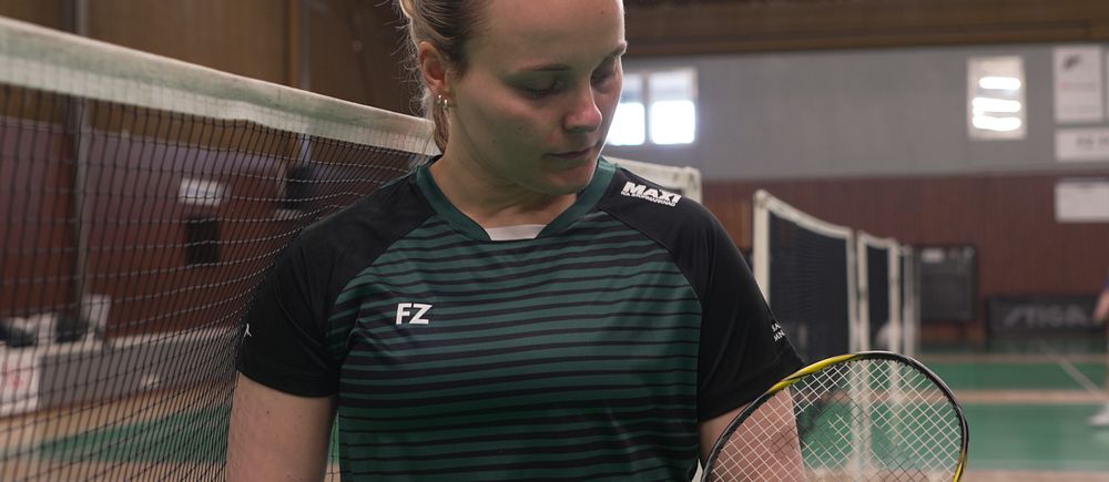 Moa Sjöö Gozzi står vid nätet i hallmiljö med racket i handen.