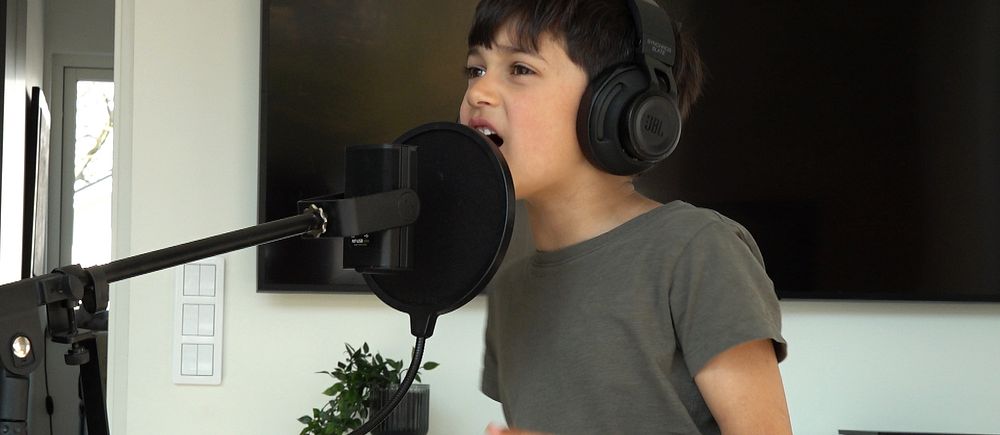 Pojke som sjunger i en mikrofon