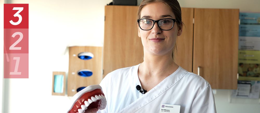 Tandläkare Sara Messerer håller en stor modell av tänder.