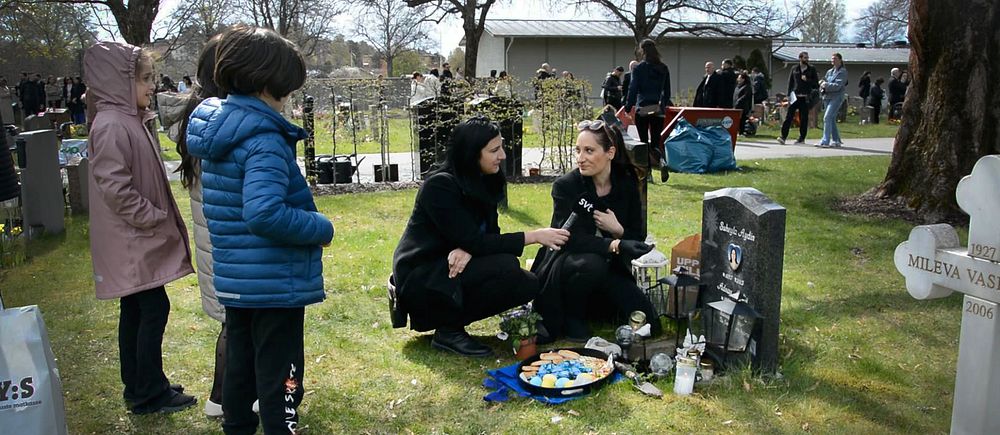 Annandag påsk firas på kyrkogården i Södertälje. En mamma sitter vid en grav med fika och godis, några barn står bredvid. .
