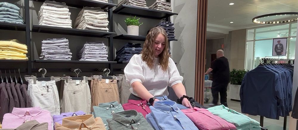 Kvinna viker kläder i butik.