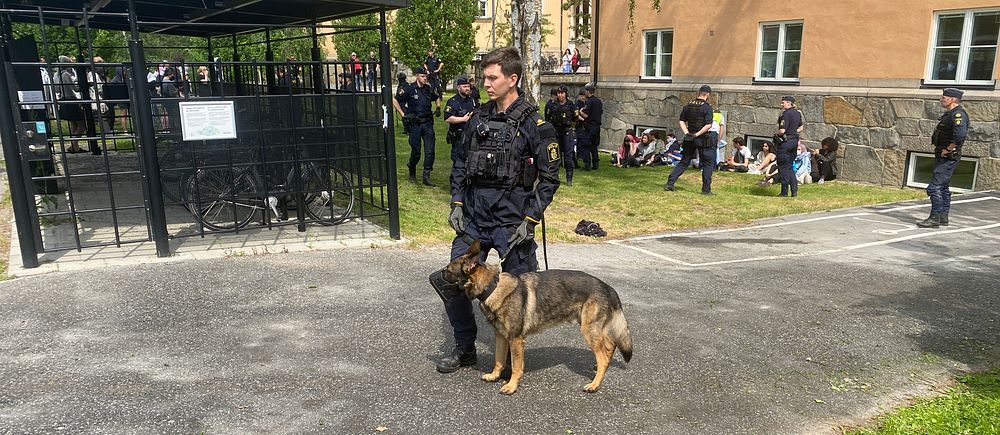 Polis med hund utanför KTH i samband med protester