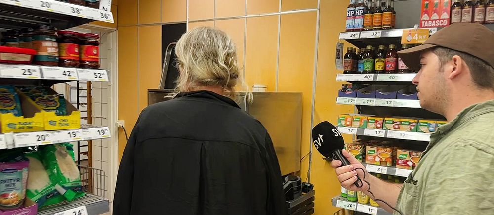 SVT-reporter med mikrofon följer med i matbutik i Grythyttan där väljare kan smita in i ett bakområde.