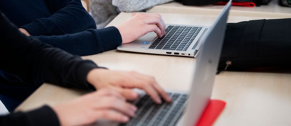 elever som knappar på datorer på skolbänk