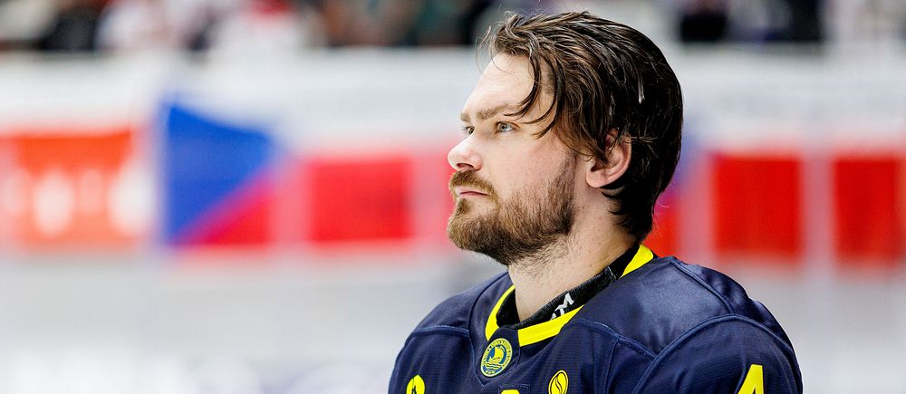 Ishockeyspelare i Tre Kronors blå-gula matchtröja med C och nummer 4 på bröstet.