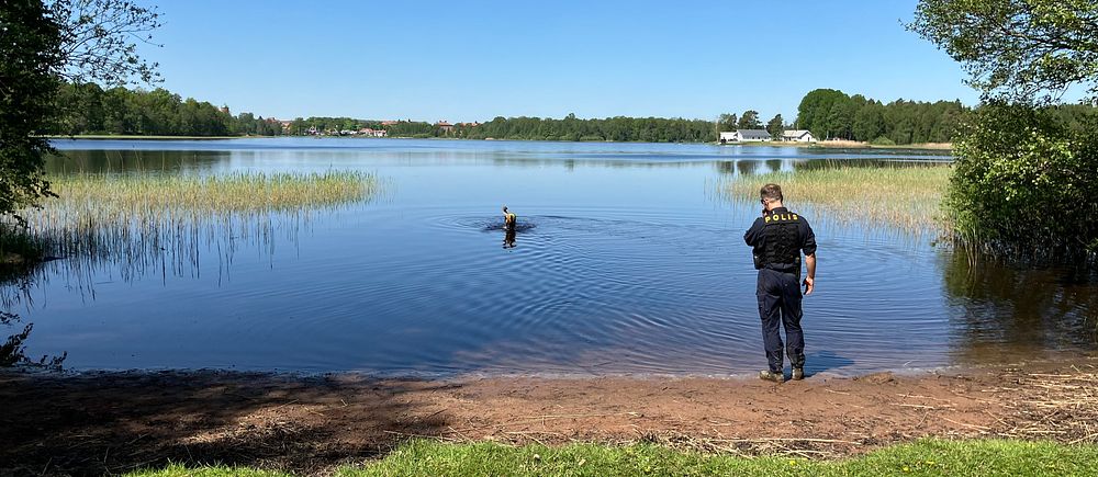 Polis och polishund vid en sjö