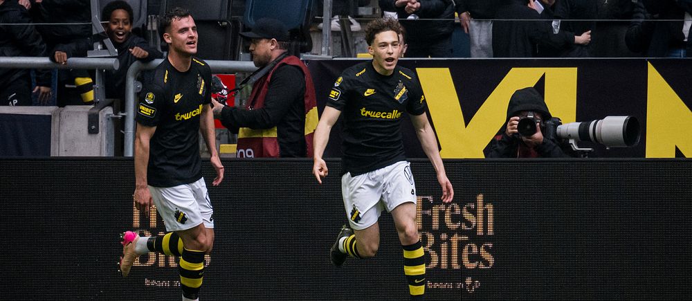 Två AIK-spelare firar ett mål inför jublande supportrar på fotbollsstadion.