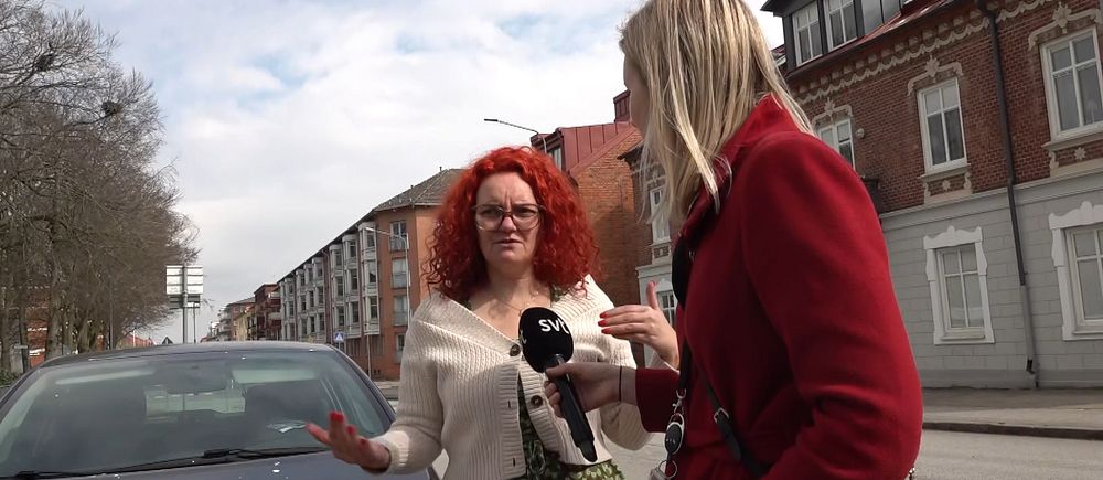 Reporter intervjuar person vid bil på gata efter skottlossning i Eslöv.