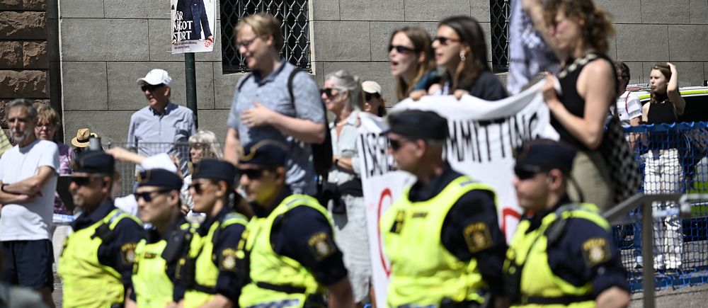 Demonstranter hålls tillbaka av poliser i Lundagård