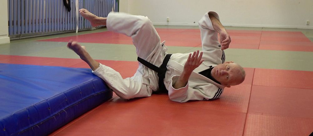 Judoinstruktören Rolf Westlund visar fallteknik i sina judokläder i övningslokalen i Göteborg.