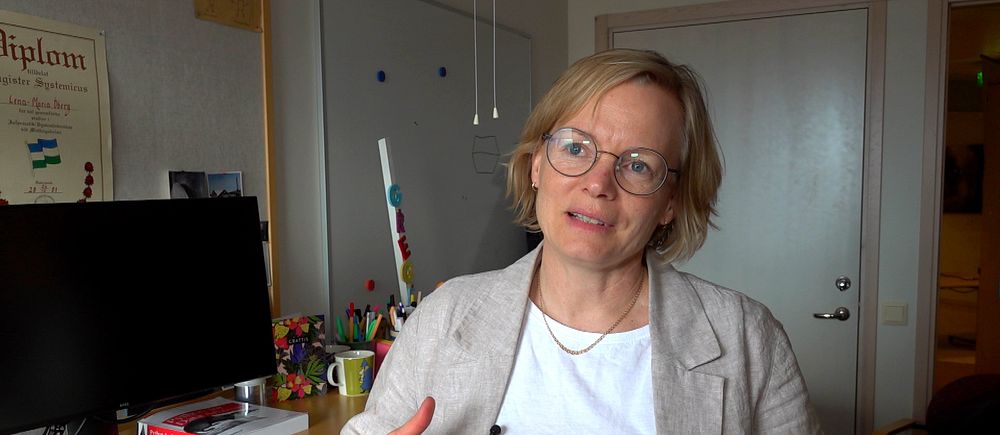 Lena-Maria Öberg, forskare vid Mittuniversitetet står vid sitt skrivbord. Hon är blond med glasögon,