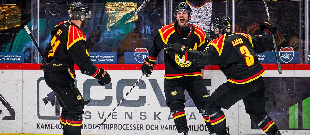 Tre hockeyspelare i Brynäs IF firar mål vid sidan av isen med sina lagkamrater.