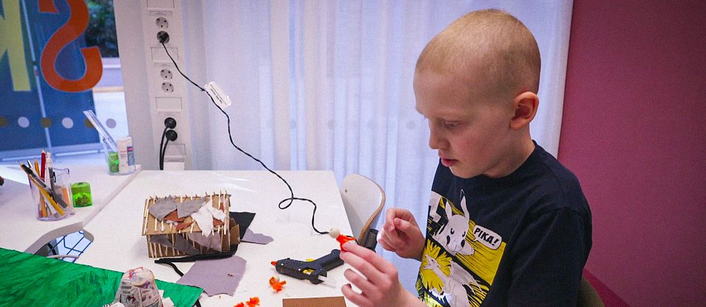 Kristjàn, 10 år, sitter i en sal och pysslar på Drottning Silvias barnsjukhus i Göteborg.