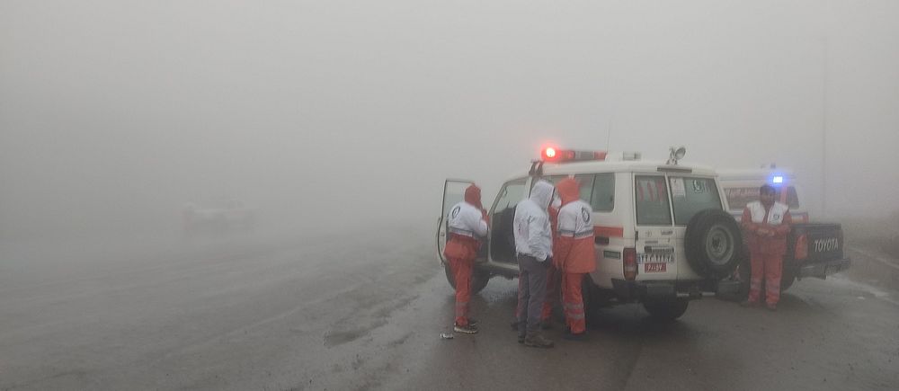 Räddningsarbetare vid en ambulans i tät dimma