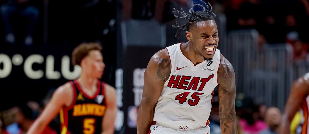 Basketspelare i Heat-uniform firar, motståndare från Hawks i bakgrunden.