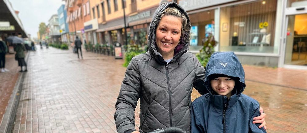 Mamma står med sin son och en barnvagn på gågatan i Skellefteå