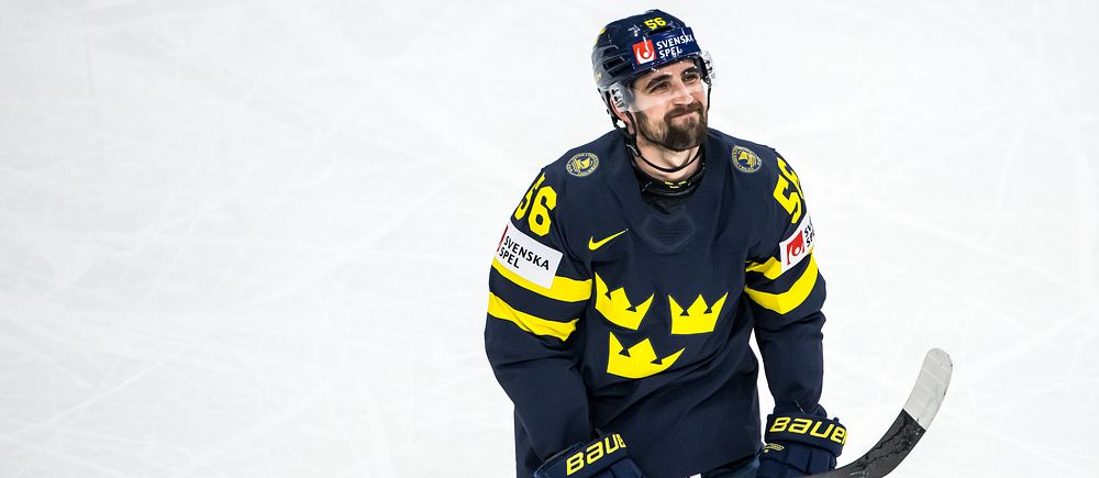 Ishockeyspelare i Sveriges landslagsdräkt på isen under match.