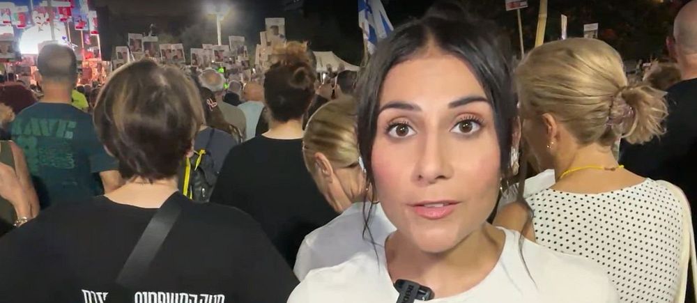 Människor samlade på en demonstration utomhus under kvällstid.