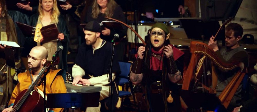 Ensemble i medeltida kläder spelar klassiska instrument på en scen.