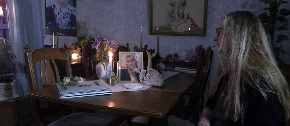 Kvinna tittar på foto av sin vuxna dotter